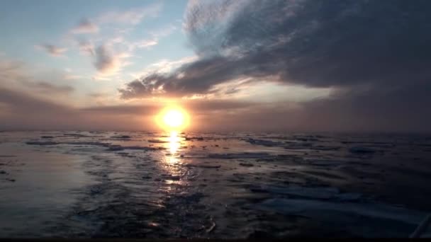 Puesta de sol en el océano entre icebergs y hielo en el Ártico . — Vídeos de Stock
