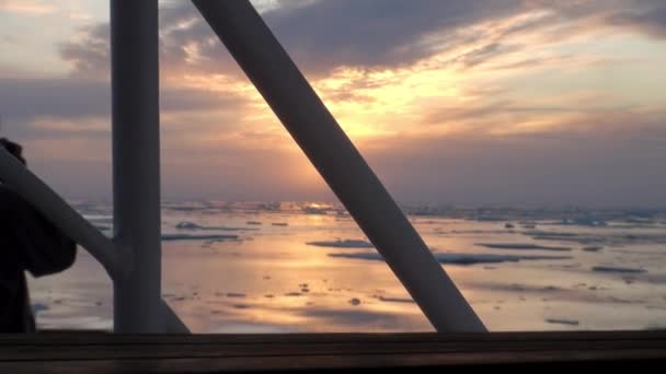 Solnedgången i havet bland isberg och is i Arktis. — Stockvideo