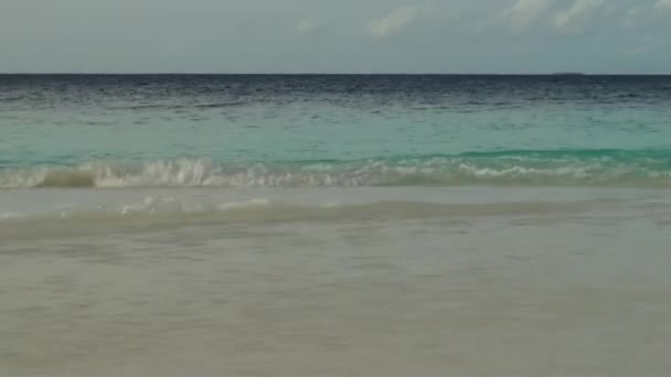 Морські хвилі подорожувати на піщаному пляжі. Мальдіви. Крупним планом. — стокове відео