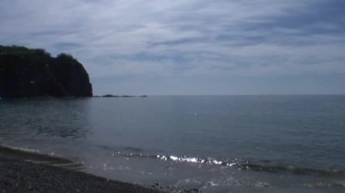 Dalgalar deniz taşlı kayalar plajda sörf. Japonya deniz.