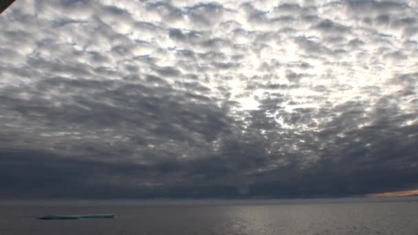 Puesta de sol en el océano entre icebergs y hielo en el Ártico . — Vídeo de stock