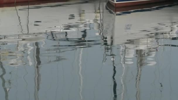 Zpomalený pohyb. Bílé jachty v přístavu, odrazy v klidné vodě, modré ranní obloze — Stock video