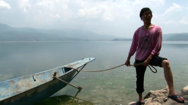 Азіатський хлопчик біля човна сампан на озері Фуксіан.. — стокове відео