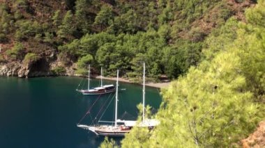 Güneş ışınları kıyı şeridi yakınlarındaki deniz suyunun yüzeyinde yatla oynar..