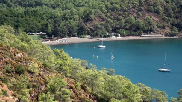 Beyaz yatlar arka planda yelken açıyor ve kıyı şeridinde dağlar.. — Stok video