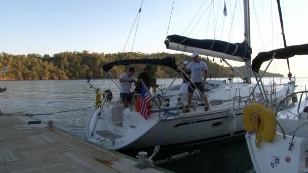 Les gens naviguent sur un yacht blanc sur fond de côte de montagne en Turquie. — Video