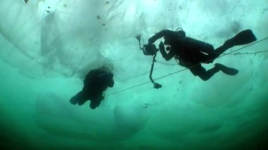 Kameralı su altı kameramanı ve Baykal Gölü 'nün buzları altında teknik dalgıç..