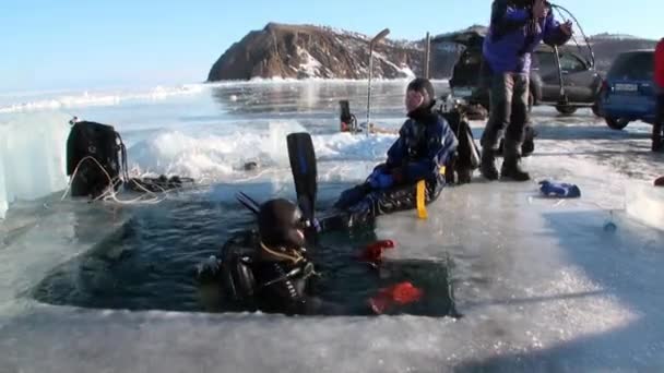 바이칼호의 얼음 구멍에서 잠수부들이 빠져 나오다. — 비디오