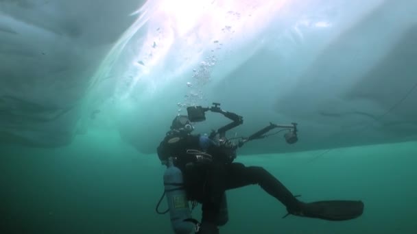 Technische duiker cameraman onder ijs in koud water van het Baikalmeer. — Stockvideo