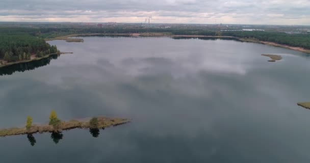 Ландшафт с видом с воздуха искусственное озеро с зеркальной поверхностью чистой воды на окраине искусственного озера с зеркальной поверхностью чистой воды в окружении густого зеленого леса Концепция наружной природы. — стоковое видео