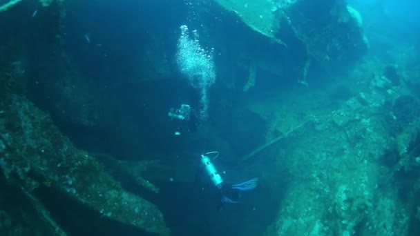 Two divers on wreck underwater on seabed of Pacific Ocean on Chuuk Islands. — Stock Video