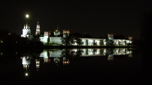 Parede de pedra branca do Convento Novodevichy, reflexão na água da lagoa à noite. — Vídeo de Stock