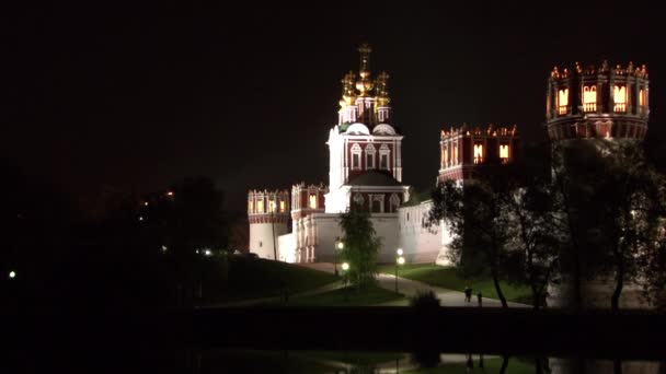 La gente cammina vicino al monastero di Novodevichy di notte a Mosca. — Video Stock
