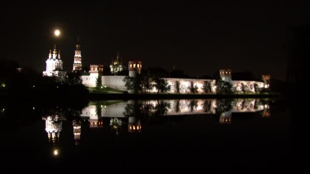 Muralla de piedra blanca del Convento Novodevichy, reflejo en agua de estanque por la noche. — Vídeo de stock