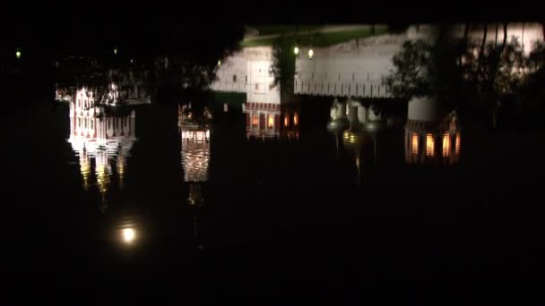 Mur de pierre blanche du couvent Novodevichy, réflexion dans l'eau de l'étang la nuit. — Video