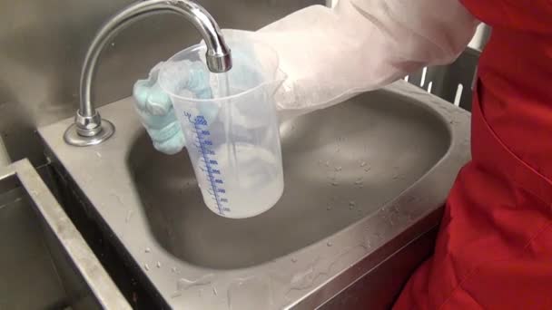 Meet het vat 1 liter met water. — Stockvideo