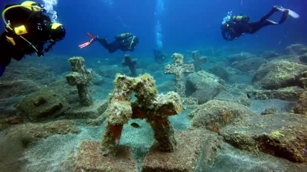 Mergulhadores perto de cruzes subaquáticas em cemitério afundado no fundo de origem vulcânica no oceano Atlântico. — Vídeo de Stock