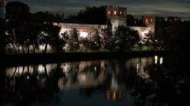 İnsanlar geceleri göl kıyısındaki Novodevichy Manastırı 'na yakın yürüyorlar..