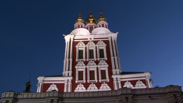 Röd kyrka med gyllene kupoler på bakgrunden av blå himmel på kvällen i Moskva. — Stockvideo