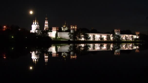 Vit stenmur av Novodevichy Convent vid dammens strand på natten. — Stockvideo