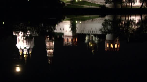 Muralla de piedra blanca del monasterio Novodevichy, reflejo en el agua del estanque por la noche. — Vídeo de stock