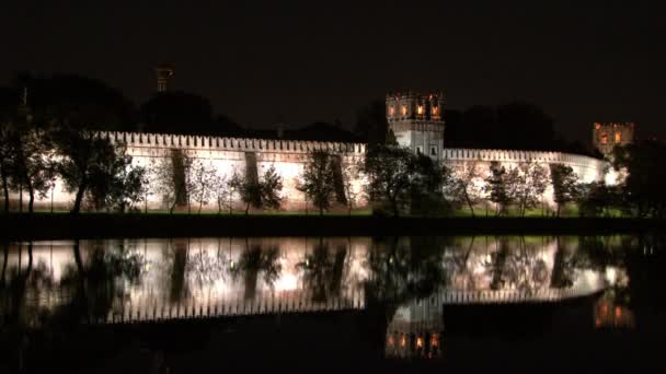 Muro di pietra bianco di monastero di Novodevichy su riva di stagno di notte. — Video Stock