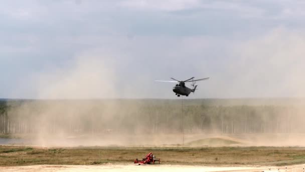 Teherszállító helikopter lebegő merőkanállal repül a tartályból.. — Stock videók