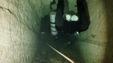 Budapeşte sualtı mağarasında kırmızı yüzgeçli teknik dalgıç.