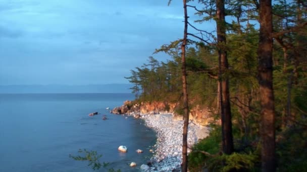 Paisagem natural no fundo de árvores verdes na costa rochosa do lago Baikal. — Vídeo de Stock