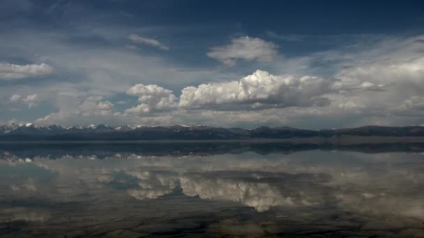 Clear transparent water with reflection of clouds in sky and snow mountains. — Stock Video