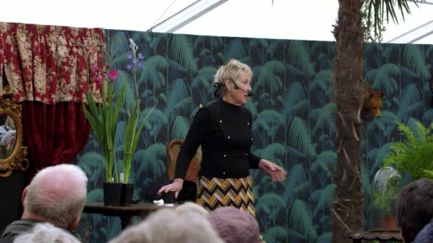 Woman speaker performs on stage in front of audience on festival of food RHS Malvern Hills. — Stock Video