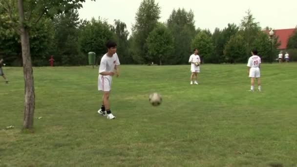 Asiatisk fotbollsspelare gör spel under företagsevenemang på sportfestival. — Stockvideo