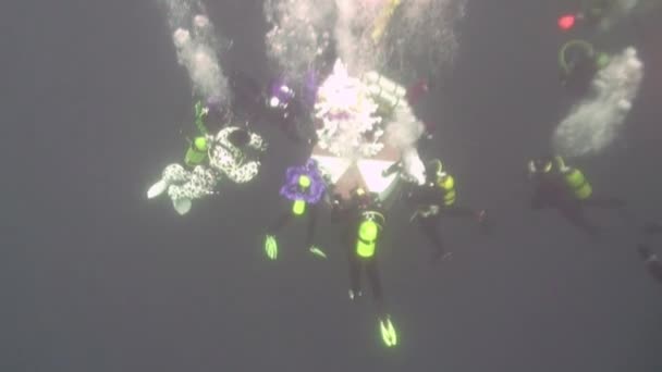 Potápěči kulatý tanec v Novém roce kolem podvodní vánoční strom. — Stock video