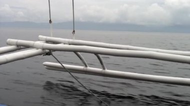 Filipinler adalarında denizde hareket eden Filipin teknesinin bambu kanatları.