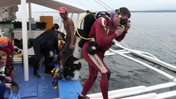 Divers divers dive into water from philippine boat with bamboo wings. — Stock Video