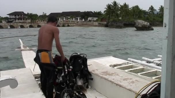 Divers on philippine boat with bamboo wings prepare to dive in sea. — Stock Video