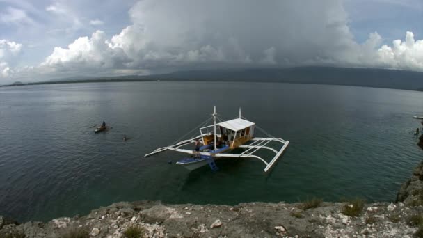 Филиппинская лодка с бамбуковыми крыльями у берегов Филиппинских островов. — стоковое видео