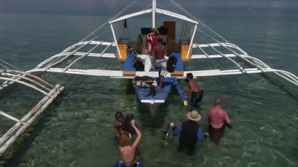 Buzos en barco filipino con alas de bambú se preparan para bucear en el mar. — Vídeo de stock