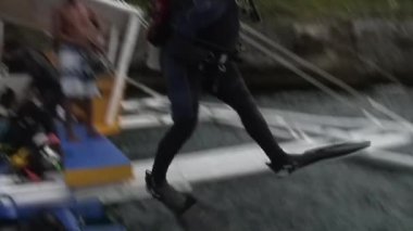 Dalgıçlar bambu kanatlarıyla Filipin teknesinden suya dalıyorlar.