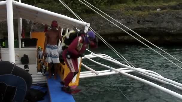 Divers divers dive into water from philippine boat with bamboo wings. — Stock Video