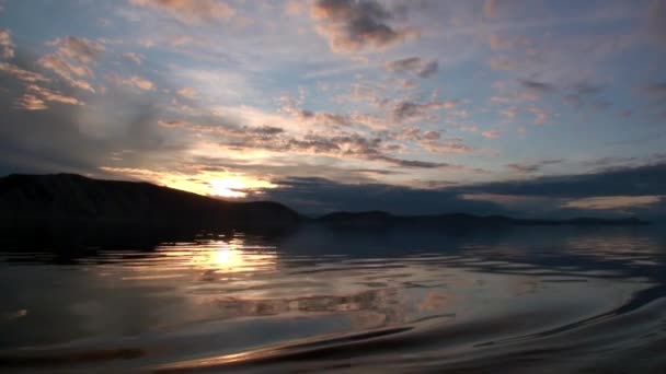 Bela paisagem do pôr do sol com nuvens cinzentas e montanhas no Lago Baikal. — Vídeo de Stock