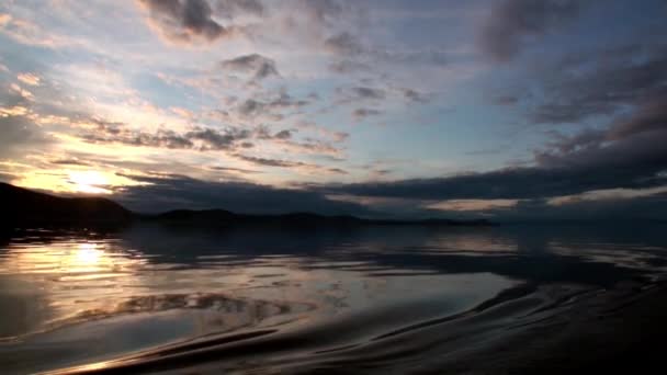 Hermoso paisaje al atardecer con nubes grises y montañas en el lago Baikal. — Vídeo de stock