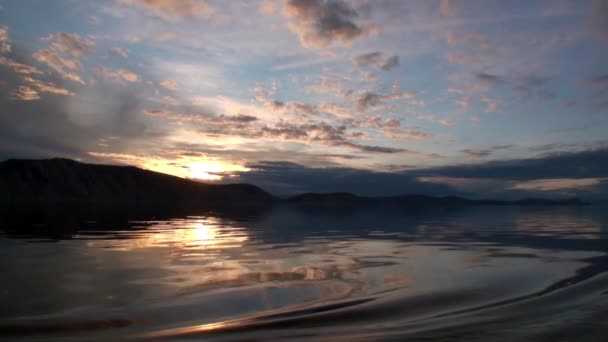 Bela paisagem do pôr do sol com nuvens cinzentas e montanhas no Lago Baikal. — Vídeo de Stock