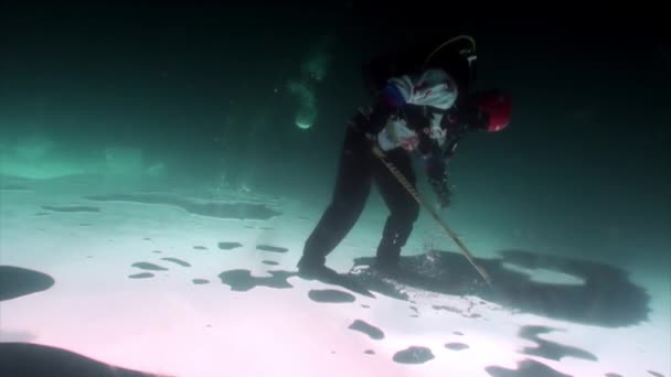 ホッケー選手でスポーツ制服でパックと棒の氷の下で撮影. — ストック動画