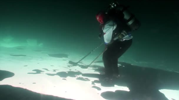 Jugadores de hockey en uniforme deportivo con disco y palo de tiro bajo el hielo. — Vídeos de Stock