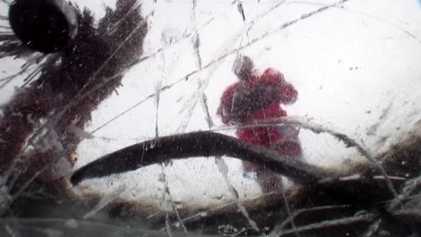 Les joueurs de hockey jouent au hockey en plein air, tirant sous la glace sur le lac Baïkal. — Video