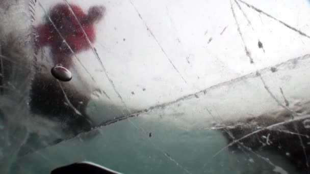 Puck de hockey y jugadores en uniforme deportivo con palo de tiro bajo el hielo. — Vídeos de Stock