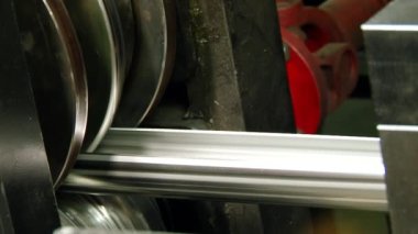 Fabrikadaki çelik borulardan oluşan metal rulo makineler üzerine yakın çekim metaller..