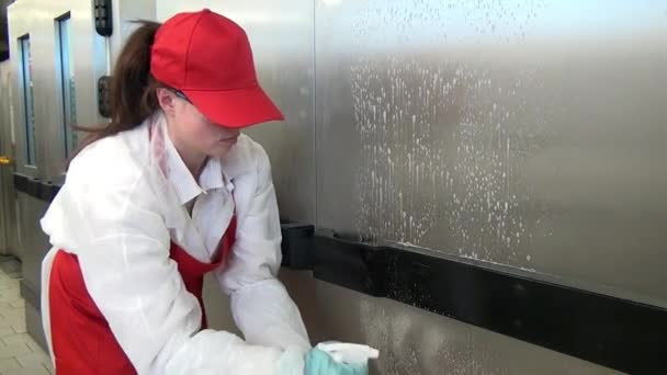 Kobieta myje drzwi przemysłowego sprzętu w warsztacie przemysłowym. — Wideo stockowe