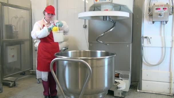 Жінка в червоному фартусі і капюшоні миє і дезінфікує колінника в харчовій промисловості.. — стокове відео